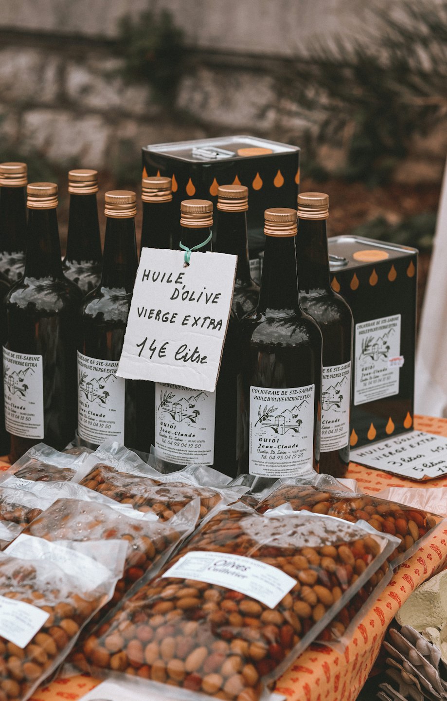 Bottiglie di olio d'oliva e olive in vendita a uno stand del mercato.